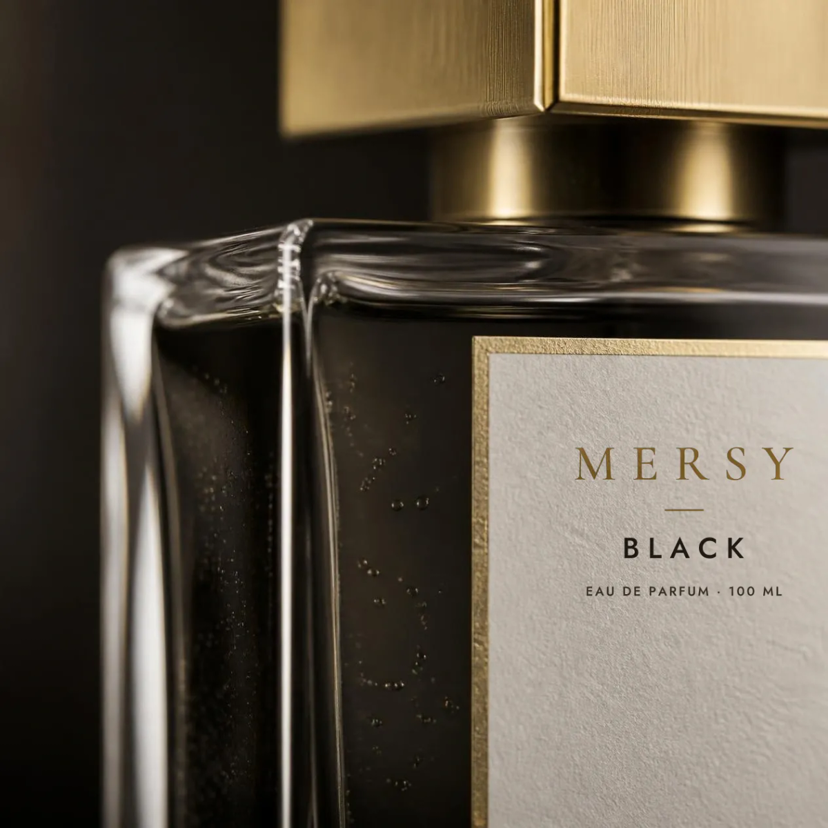 Close-up of the MERSY label on the Black bottle: the gold MERSY wordmark above the words Black, Eau de Parfum, 100 ml.